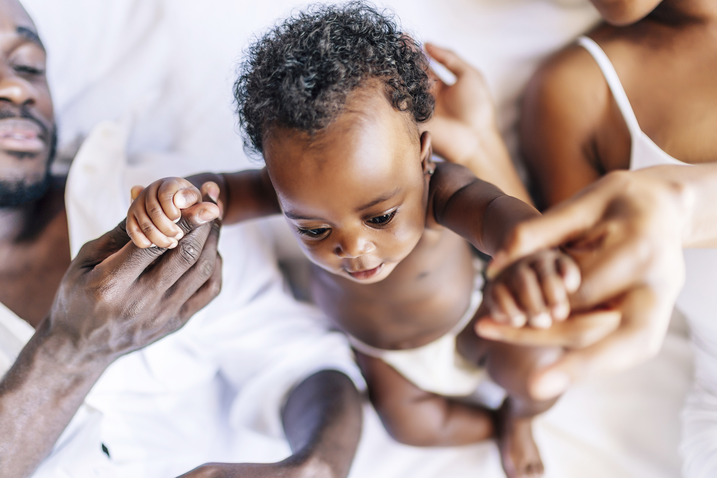 A cheerful family of African-Americans with a mother, father and baby having fun together